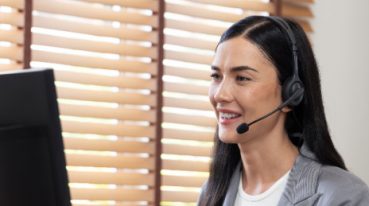 virtual receptionist with headset answering the phone seated at a desk