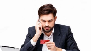 a lawyer considers paying for a service with a card while on his phone